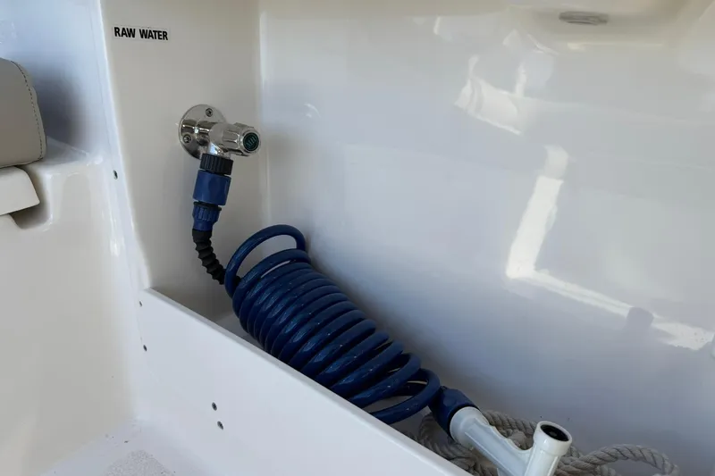 Slide: The Image of 2023 Key West 239 DFS boat raw water hose connection with coiled blue hose. - 29