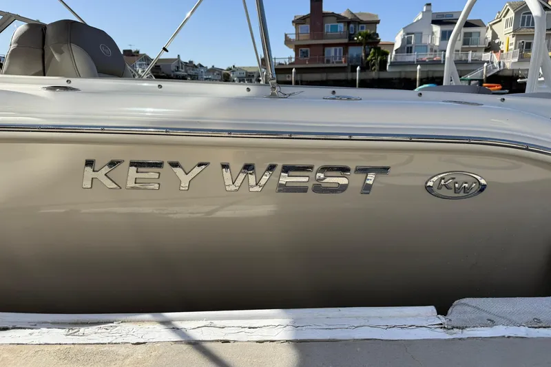 Slide: The Image of 2023 Key West 239 DFS boat side view with logo and waterfront background. - 4
