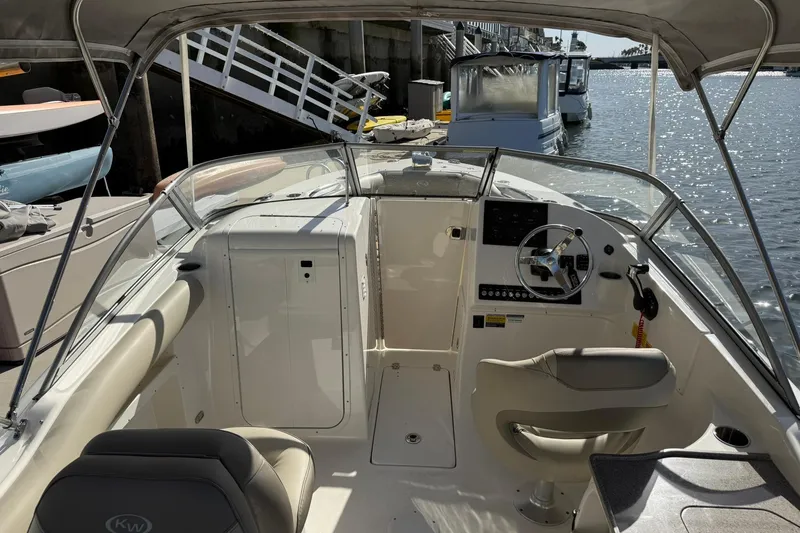 Slide: The Image of 2023 Key West 239 DFS boat interior at dock, featuring steering wheel and seating. - 8