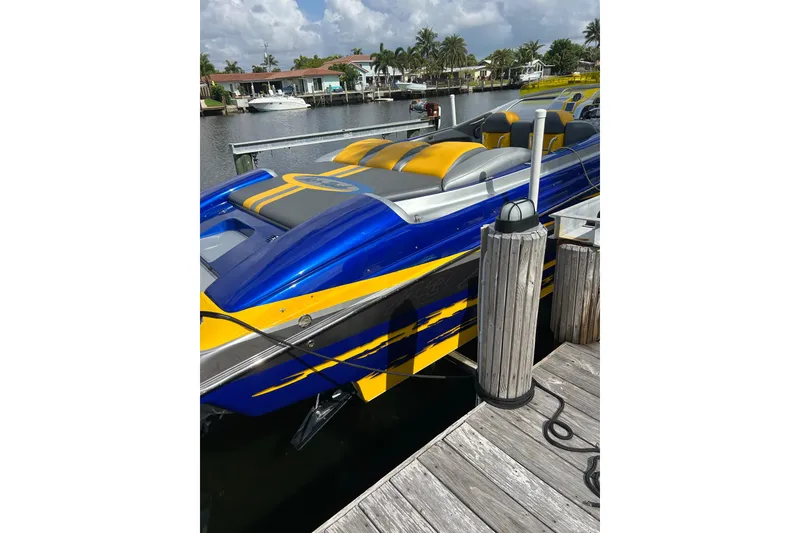 Slide: The Image of 2008 Nor-Tech 4300V powerboat docked, featuring vibrant blue and yellow design. - 6