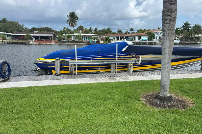 Slide: The Image of 2008 Nor-Tech 4300V boat docked by waterfront homes, under cloudy sky. - 8