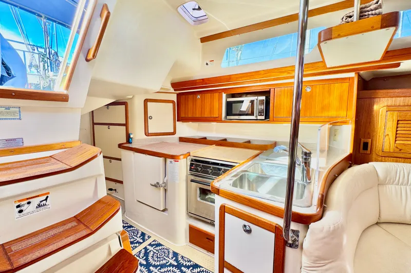 Slide: The Image of Interior of a 2005 Catalina 42 MkII sailboat, featuring a modern kitchen and cozy seating area. - 20