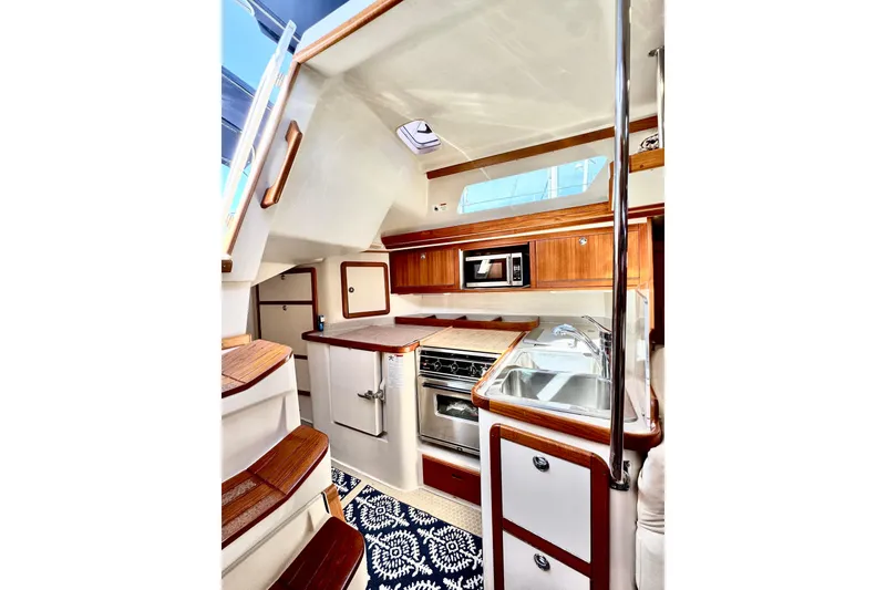 Slide: The Image of Interior of 2005 Catalina 42 MkII yacht, featuring a modern kitchen with wood accents. - 24