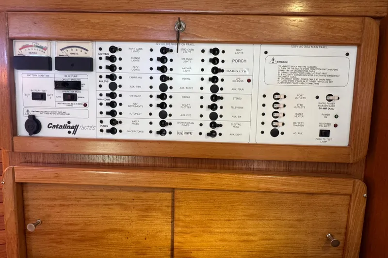 Slide: The Image of Electrical control panel of a 2005 Catalina 42 MkII yacht, featuring various switches and gauges. - 27