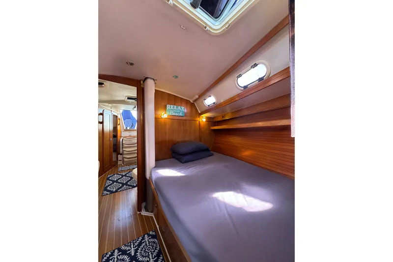 Slide: The Image of Cozy cabin interior of 2005 Catalina 42 MkII sailboat with bed and nautical decor. - 31