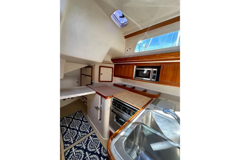 Slide: The Image of 2005 Catalina 42 MkII yacht kitchen with wood cabinetry and modern appliances. - 36