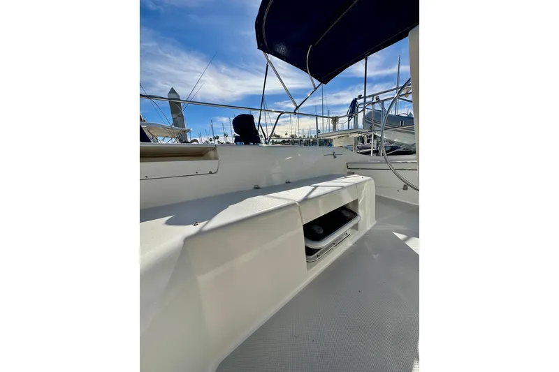 Slide: The Image of 2005 Catalina 42 MkII sailboat cockpit with blue canopy, docked under clear sky. - 48