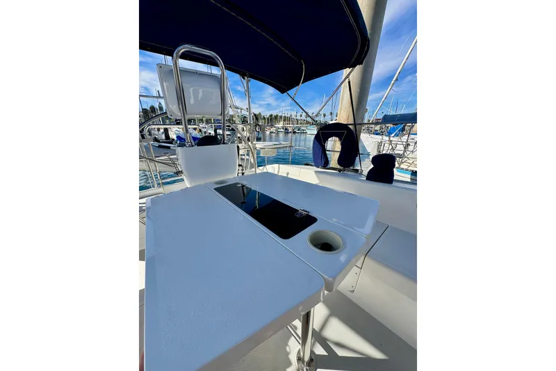 Slide: The Image of Cockpit view of 2005 Catalina 42 MkII sailboat with table and marina background. - 49