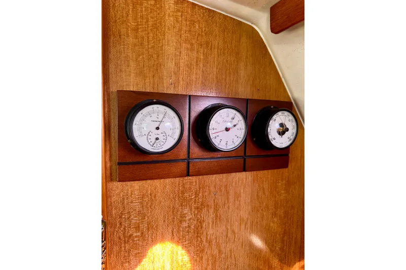 Slide: The Image of Wooden panel with three nautical gauges on a 2005 Catalina 42 MkII sailboat. - 59