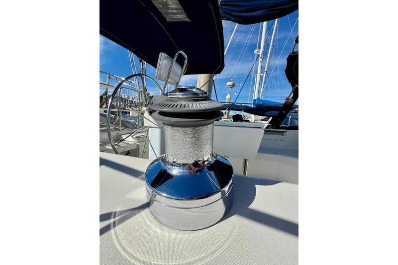 Slide: The Image of Shiny winch on 2005 Catalina 42 MkII sailboat deck, with steering wheel and blue sky background. - 9