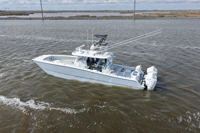 Slide: The Image of 2025 Freeman 42LR boat cruising on open water with triple outboard engines. - 13