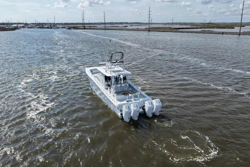 Slide: The Image of 2025 Freeman 42LR boat cruising on a wide river under a partly cloudy sky. - 15