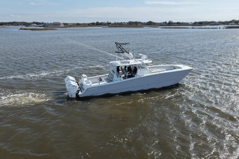 Slide: The Image of 2025 Freeman 42LR boat cruising on a calm lake under a clear sky. - 19