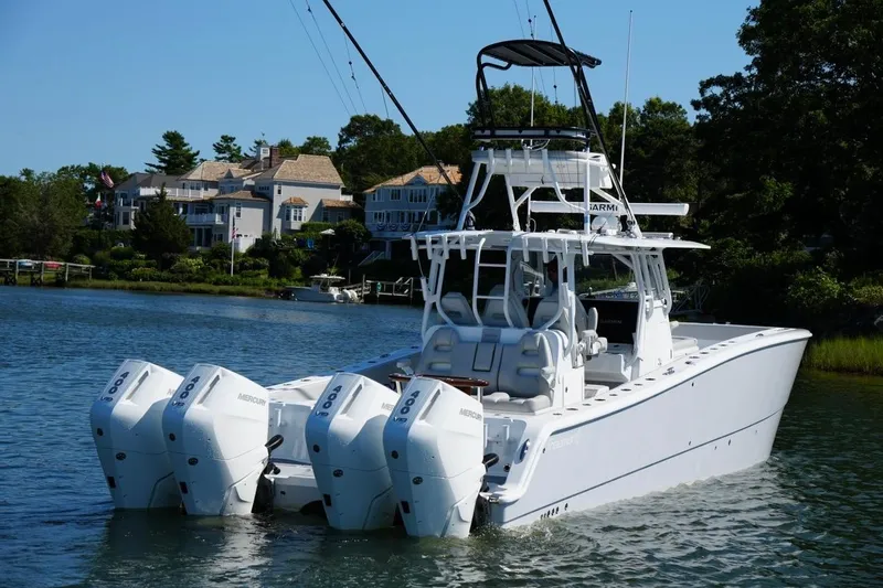 Slide: The Image of Luxury Freeman 42 LR boat with four engines cruising near waterfront homes, 2025 model. - 33