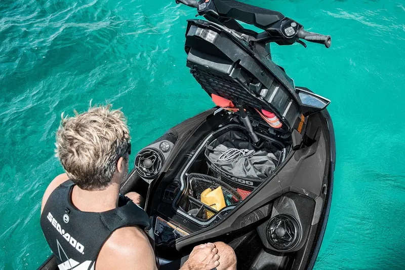 Slide: The Image of Manufacturer Provided Image: Man on 2026 Sea-Doo GTX Limited 325, exploring storage compartment on turquoise water. - 6