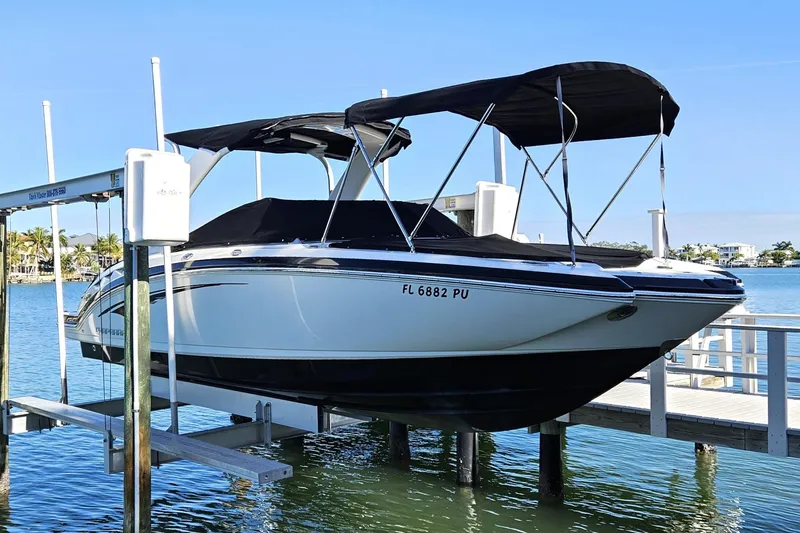 The Image of 2015 Chaparral 264 Sunesta boat docked on lift by waterfront. - 1