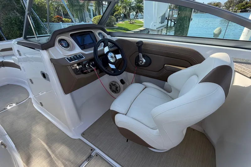 Slide: The Image of 2015 Chaparral 264 Sunesta boat interior with steering wheel and captain's chair. - 14