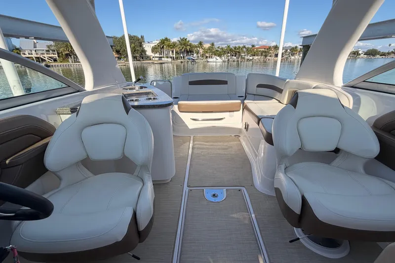 Slide: The Image of 2015 Chaparrall 264 Sunesta boat interior with plush seating and scenic waterfront view. - 15