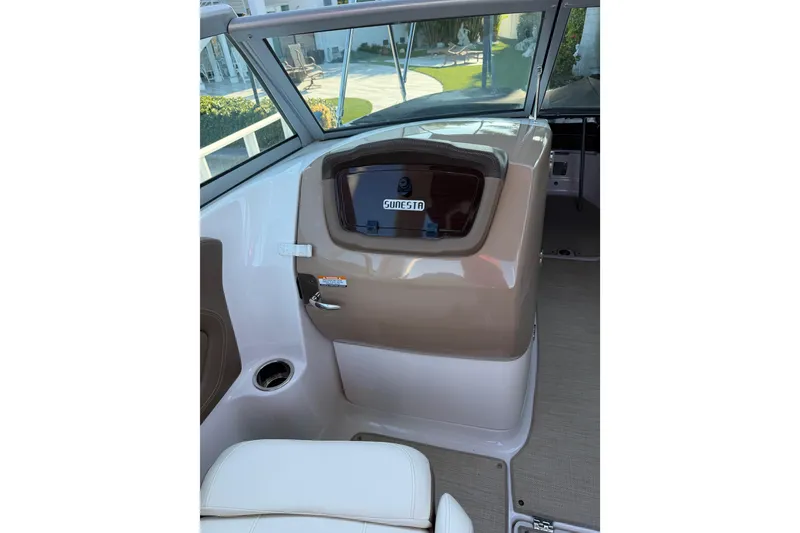 Slide: The Image of 2015 Chaparrall 264 Sunesta boat interior with beige dashboard and seating. - 16
