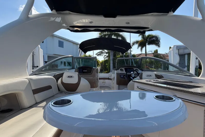 Slide: The Image of 2015 Chaparrall 264 Sunesta boat interior with seating, table, and steering wheel. - 20