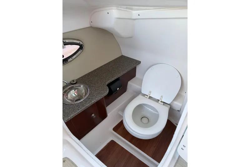 Slide: The Image of 2015 Chaparrall 264 Sunesta boat bathroom with toilet, sink, and countertop. - 24