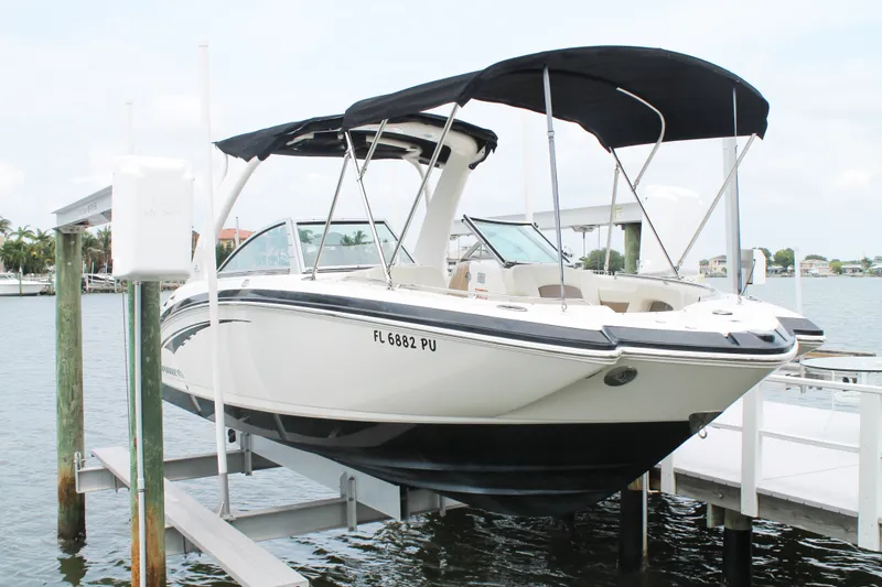 Slide: The Image of 2015 Chaparral Sunesta 264 boat docked on lift, featuring black canopy and sleek design. - 28