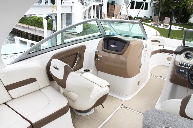 Slide: The Image of 2015 Chaparral Sunesta 264 boat interior with beige and brown seating, modern dashboard. - 35
