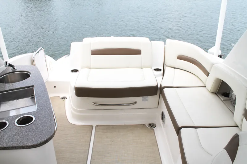 Slide: The Image of 2015 Chaparral Sunesta 264 boat interior with seating and kitchenette by the water. - 37