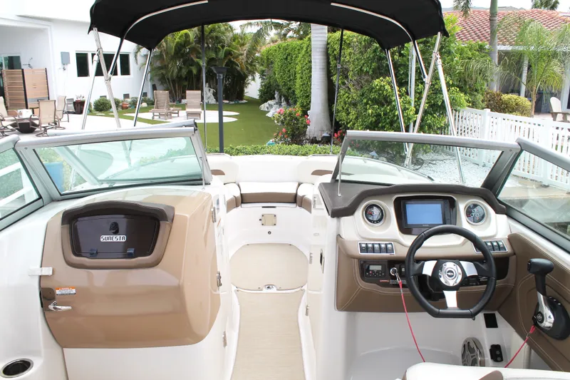 Slide: The Image of 2015 Chaparral Sunesta 264 boat interior with steering wheel, dashboard, and seating area. - 40