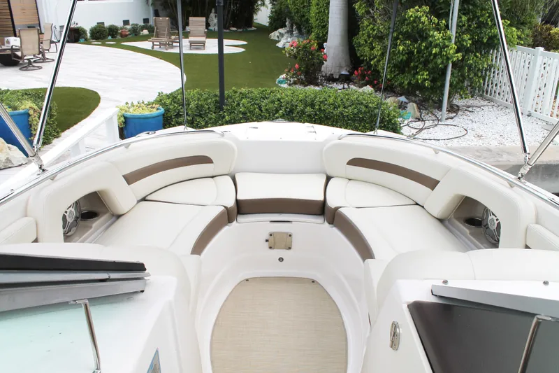Slide: The Image of 2015 Chaparral Sunesta 264 boat interior with white and brown seating, outdoor setting. - 30