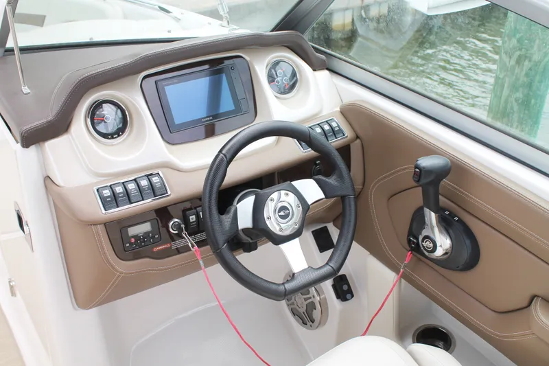 Slide: The Image of 2015 Chaparral Sunesta 264 boat dashboard with steering wheel and control panel. - 36