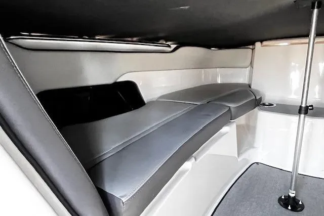 Slide: The Image of 2024 Yamaha Boats AR250 interior cabin with cushioned seating and sleek design. - 12