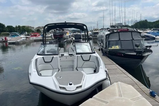 Slide: The Image of 2024 Yamaha Boats AR250 docked at a marina with other boats. - 8