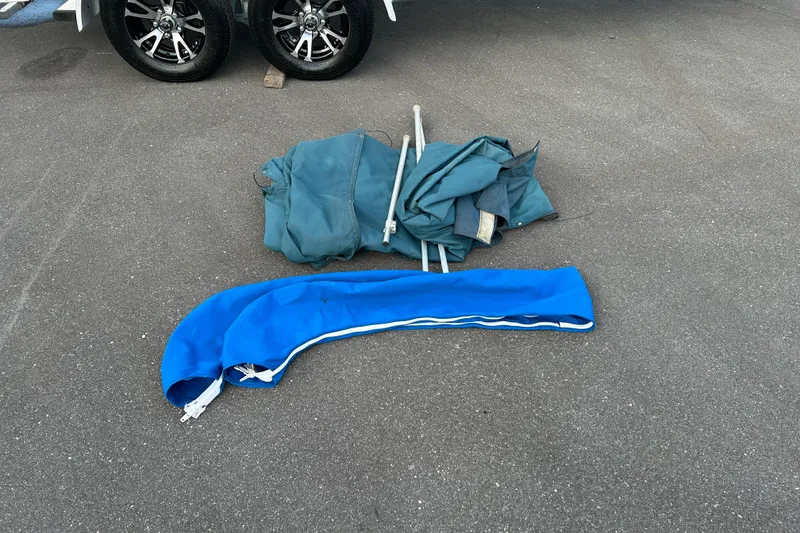 Slide: The Image of Blue and green boat covers with poles on asphalt, near Hurricane Sundeck Sport 218 OB. - 20