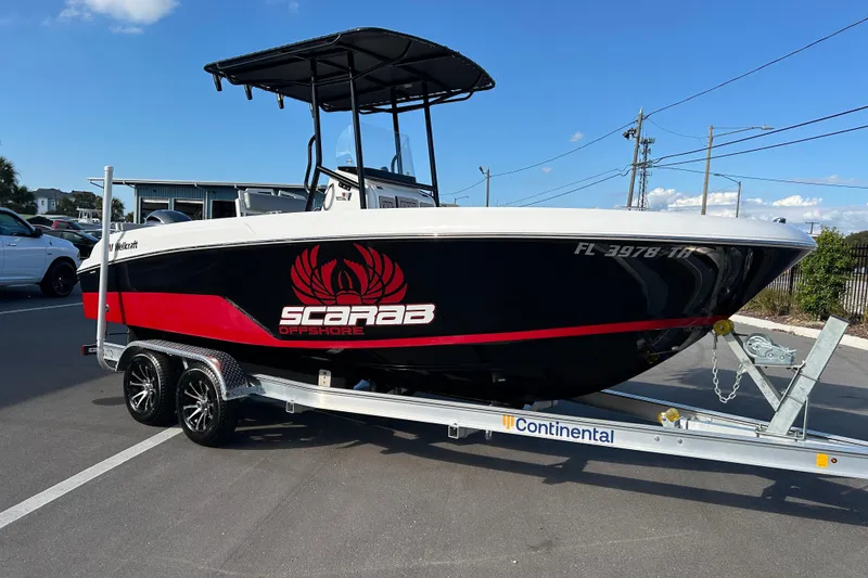 The Image of 2022 Wellcraft 202 Fisherman boat on trailer, black with red Scarab Offshore logo. - 1
