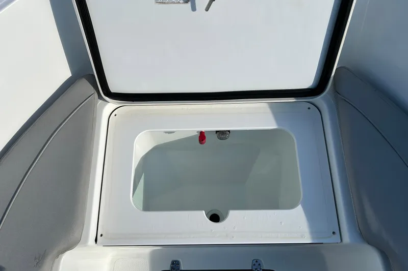 Slide: The Image of 2022 Wellcraft 202 Fisherman boat storage compartment, open lid, white interior. - 14