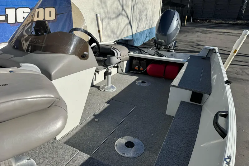 Slide: The Image of 2010 Alumacraft Fisherman 145 CS boat interior with seating and motor. - 10