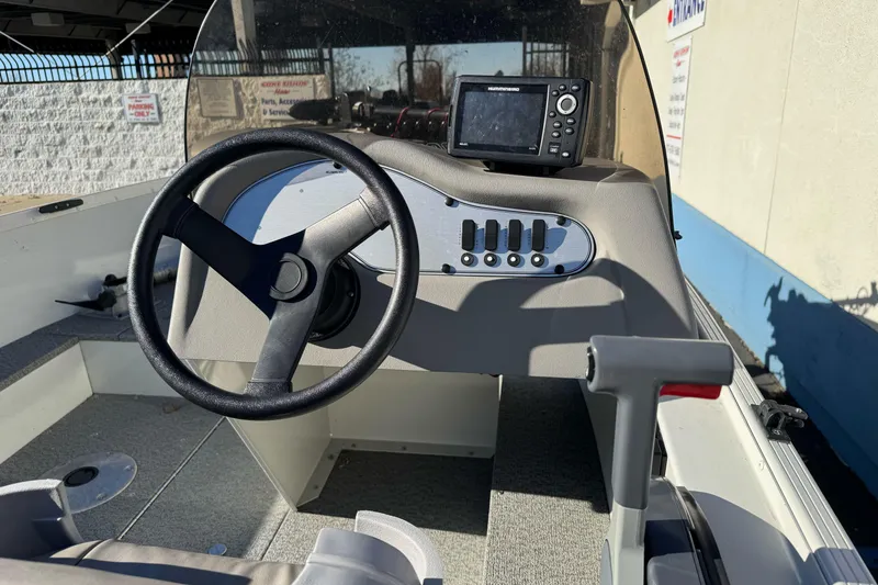 Slide: The Image of 2010 Alumacraft Fisherman 145 CS boat dashboard with steering wheel and navigation system. - 6