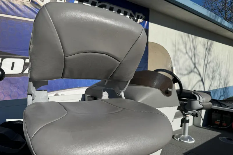 Slide: The Image of 2010 Alumacraft Fisherman 145 CS boat seat, gray upholstery, outdoor setting. - 9