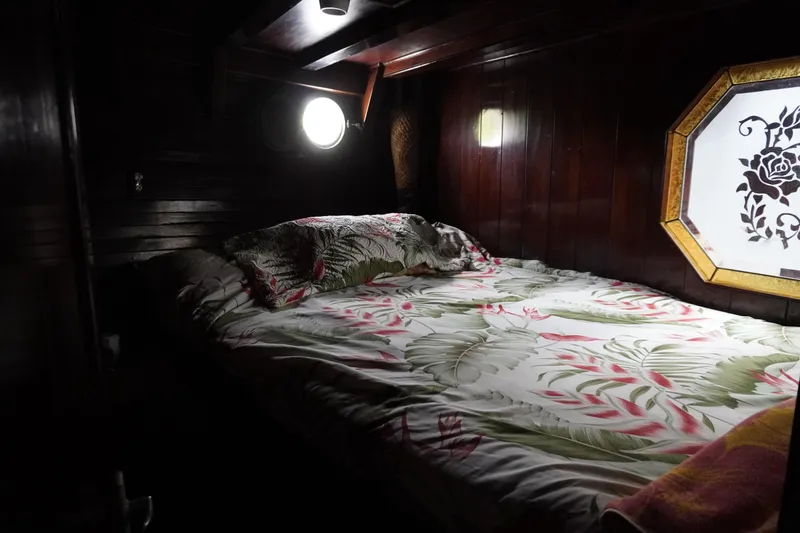 Slide: The Image of Cozy cabin interior of 1976 Manila Shipbuilders sailboat with floral bedding and wooden walls. - 12
