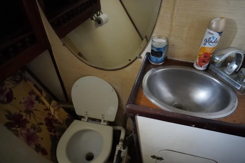 Slide: The Image of Compact sailboat bathroom with toilet, sink, and floral curtain, Manila Shipbuilders 1976 model. - 16