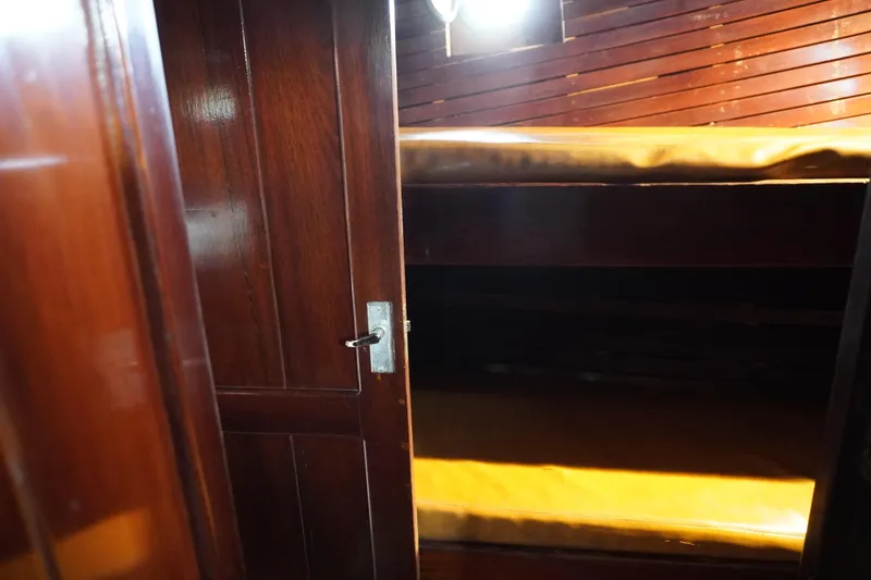 Slide: The Image of Interior of a 1976 Manila Shipbuilders sailboat with wooden bunk beds. - 17