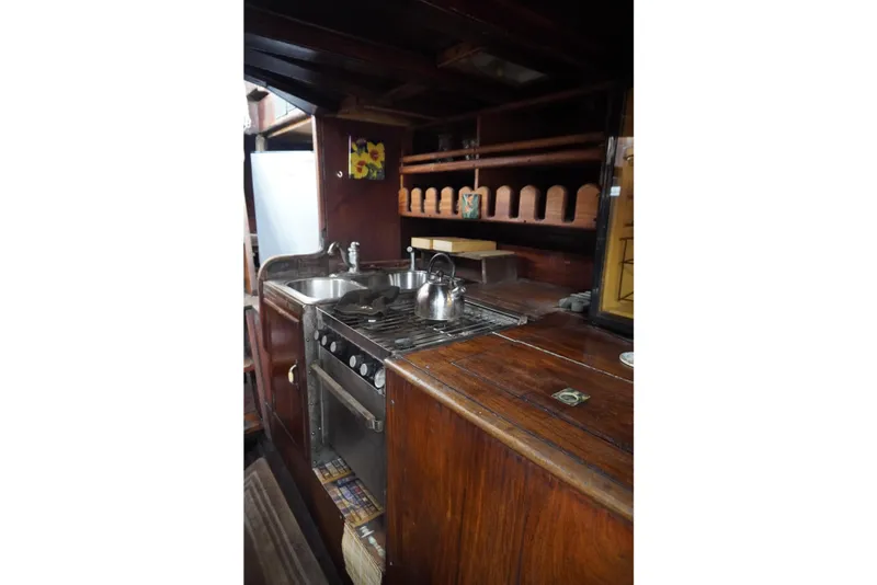 Slide: The Image of 1976 Manila Shipbuilders sailboat kitchen with wooden cabinetry and stainless steel sink. - 23