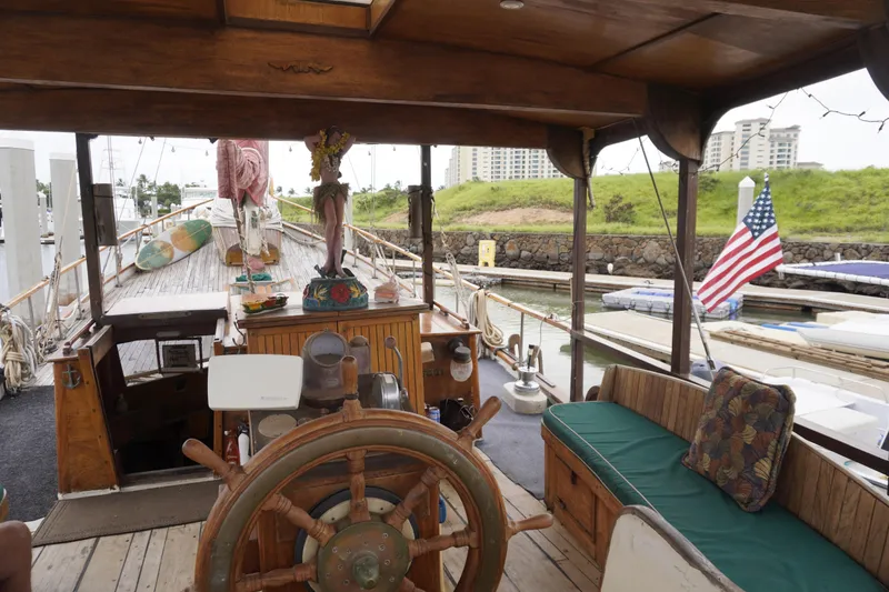 Slide: The Image of 1976 Manila Shipbuilders sailboat interior with wooden helm, American flag, and decorative elements. - 26