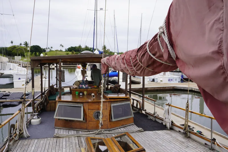 Slide: The Image of 1976 Manila Shipbuilders sailboat docked at marina, featuring wooden deck and covered sail. - 3