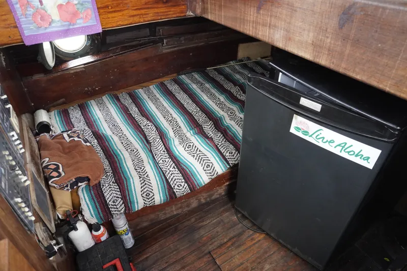 Slide: The Image of 1976 Manila Shipbuilders sailboat interior with bed, fridge, and "Live Aloha" sticker. - 37