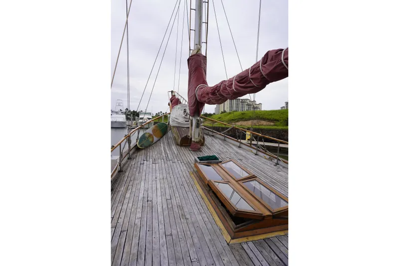 Slide: The Image of 1976 Manila Shipbuilders sailboat deck with wooden planks and covered sails. - 48