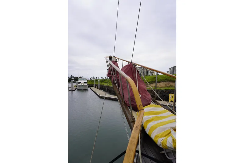 Slide: The Image of 1976 Manila Shipbuilders sailboat docked in a marina, featuring wooden railings and covered sails. - 50