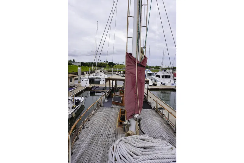 Slide: The Image of 1976 Manila Shipbuilders sailboat docked at marina, showcasing wooden deck and rigging. - 51