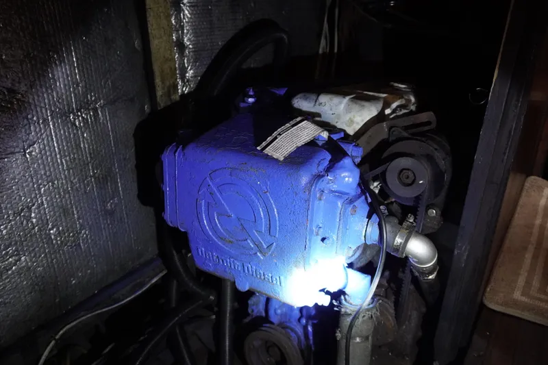 Slide: The Image of Blue engine inside a 1976 Manila Shipbuilders sailboat, illuminated in a dimly lit space. - 55